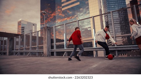 Multiethnic Diverse Group of Friends Playing Soccer on Rooftop Urban City Spot at Sunset. Stylish Young Man Dribbling, Passing Opponents Alone with the Ball, Goalkeeper Saving the Ball - Powered by Shutterstock