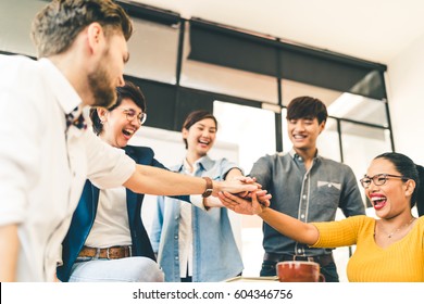 Multiethnic Diverse Group Of Happy Colleagues Join Hands Together. Creative Team, Casual Business Coworker, Or College Students In Project Meeting At Modern Office. Startup Or Teamwork Concept