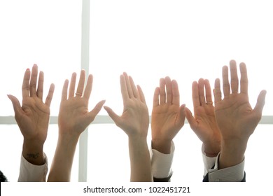 Multi-ethnic diverse people hands lifted up in the air, black and white palms raised as volunteering, initiative and engagement concept, business team training, activists get involved, close up view - Shutterstock ID 1022451721
