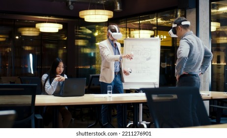 Multi-ethnic engineers in VR headsets, using laptop and wireless controllers, examining blueprint, watching data, working in modern office of hi-tech company. Cyberspace digital technology - Powered by Shutterstock