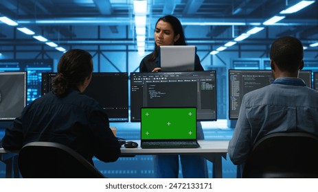 Multiethnic engineers working in high tech server hub, using green screen laptop and PCs to analyze data. Diverse employees examining infrastructure in data center, using chroma key notebook - Powered by Shutterstock - Get 15% off with code: PIKWIZARD15