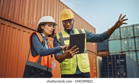 Multiethnic Female Industrial Engineer with Tablet and Black African American Male Supervisor in Hard Hats and Safety Vests Stand in Container Terminal. Colleagues Talk About Logistics Operations.