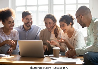Multi-ethnic five laughing buddies sit on couch indoors watching on computer comedy movie enjoy free time with best friends on weekend, multiracial mates make video call distant communication concept - Shutterstock ID 1653684670