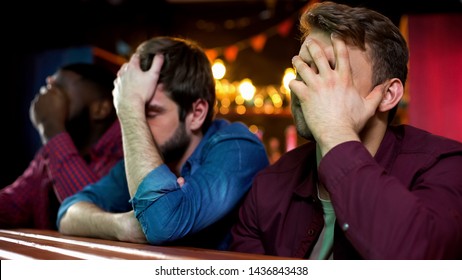 Multiethnic football fans making facepalm, disappointed with game loss, bar