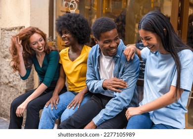 Multi-ethnic friends in a coffee shop sitting in the doorway of the shop window, having a lot of laughs - Shutterstock ID 2277105989