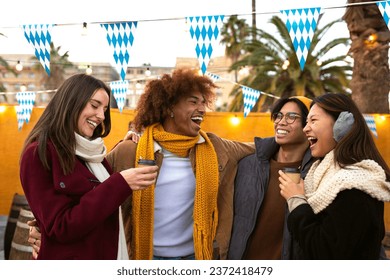 Multiethnic friends enjoying coffee outdoors on a winter day. College students in a party outside drinking hot chocolate - Powered by Shutterstock