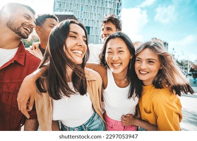 Multiethnic friends having fun walking on city street - Group of young people enjoying summer vacation together - Friendship concept with guys and girls hanging outside on a sunny day 
