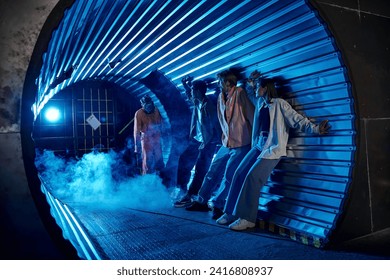 multiethnic friends standing in tunnel near freaky people in gas masks, quest room adventure - Powered by Shutterstock