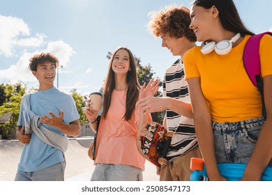 Multiethnic friends students guys girls teenagers school pupils hanging outside on a sunny day having fun walking on city street urban nature park enjoying summer vacation together. Friendship concept - Powered by Shutterstock