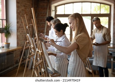 Multiethnic group of art school students drawing in paints at easels, standing in row, using brushes, enjoying creative activities, craft hobby, mastering, improving new skills, taking workshop - Powered by Shutterstock