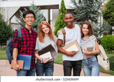 Multiethnic group of cheerful young students standing together outdoors - Powered by Shutterstock