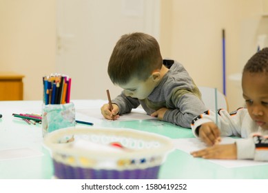 A Multi-ethnic Group Of Children In A School Desk