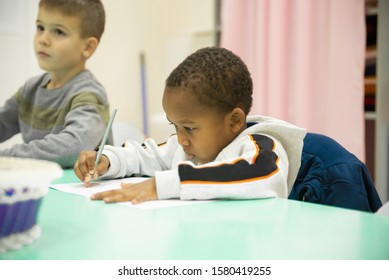 A Multi-ethnic Group Of Children In A School Desk