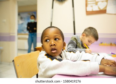 A Multi-ethnic Group Of Children In A School Desk