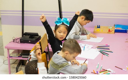 A Multi-ethnic Group Of Children In A School Desk