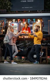 Multiethnic Group Of Customers Toasting And Eating In Front Of Modified Truck For Mobile Fast Food Service