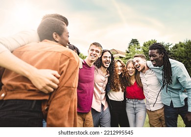 Multiethnic Group Of Diverse Young People Having Fun Hugging Together Walking Laughing And Interacting Together Arm On Shoulders In The Park - Unity, Brotherhood, Closeness And Youth Culture Lifestyle