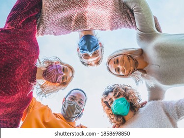 Multiethnic Group Of Friends With Face Mask In Circle - Diverse People Of Different Ethnicities Smiling And Looking Up At The Camera In Coronavirus Time - Concepts Of Friendship, Teamwork