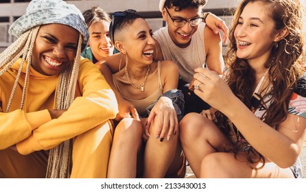 Multiethnic group of friends having fun together. Group of generation z friends laughing cheerfully while hanging out together outdoors in the city. Happy young friends making memories together. - Shutterstock ID 2133430013