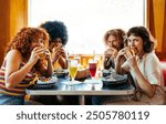 Multiethnic group of friends having meal at 80s vintage diner restaurant - Multiracial young people bonding and having fun, eating in an american fast food burger house