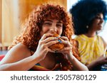 Multiethnic group of friends having meal at 80s vintage diner restaurant - Multiracial young people bonding and having fun, eating in an american fast food burger house