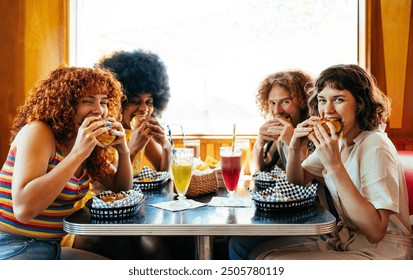 Multiethnic group of friends having meal at 80s vintage diner restaurant - Multiracial young people bonding and having fun, eating in an american fast food burger house - Powered by Shutterstock