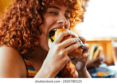 Multiethnic group of friends having meal at 80s vintage diner restaurant - Multiracial young people bonding and having fun, eating in an american fast food burger house