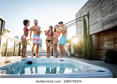 Multi-ethnic group of friends having party on  rooftop - Happy people bonding and having fun - Shutterstock ID 1084758194