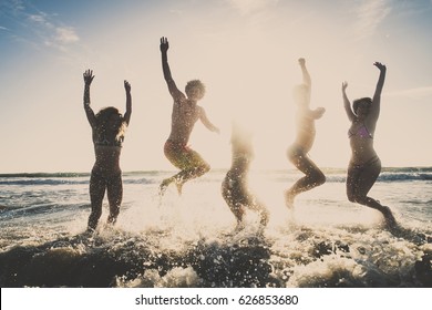 Multi-ethnic group of friends jumping on the beach - Young people having fun in the sea during summer holidays - Shutterstock ID 626853680