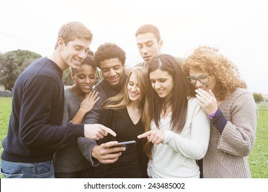 Multiethnic Group Of Friends Looking At Mobile Phone