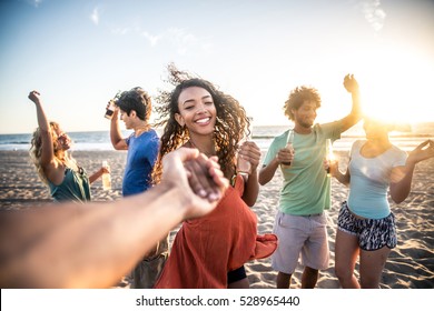 Multi-ethnic Group Of Friends Partying On The Beach At Sunset, Pov Prospective - Woman Taking His Boyfriend To Dance