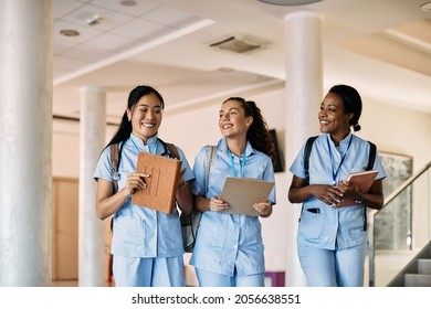 Multi-ethnic group of happy nursing students walking through medical university corridor. 