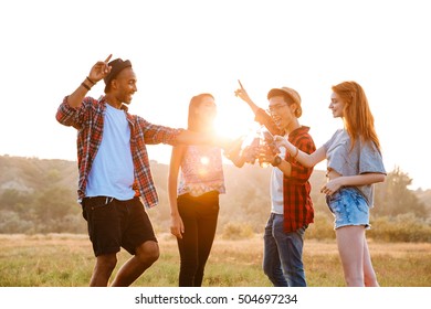 Multiethnic Group Of Happy Young Friends Drinking Beer And Soda And Having Fun Outdoors