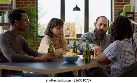 Multiethnic Group Of People Playing Board Games Activity, Enjoying Fun Gathering With Chess And Alcoholic Drinks. Smiling Friends Looking At Competition Match With Success Strategy.