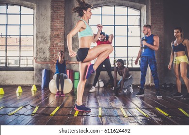 Multi-ethnic Group Of People Training In A Gym - Personal  Trainer And Sportive Persons  In A Fitness Class