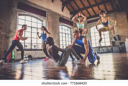 Multi-ethnic Group Of People Training In A Gym - Personal  Trainer And Sportive Persons  In A Fitness Class