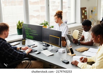 Multiethnic group of programmers working on computer and making plan in team during work with new project - Powered by Shutterstock