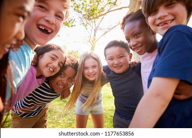 Multi-ethnic group of schoolchildren laughing and embracing