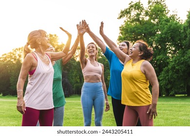 Multiethnic group of senior women training at park with fitness instructor - Active elderly people doing sport in the nature - Powered by Shutterstock