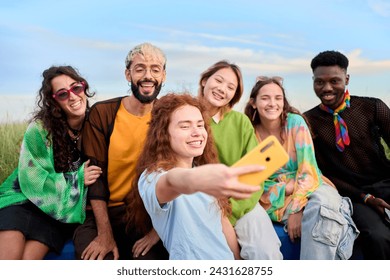 Multi-ethnic group smiling generation z boys and girls taking selfie outdoors. Happy lifestyle concept of friendship in multicultural young people having fun day together. Partners enjoying weekend.  - Powered by Shutterstock