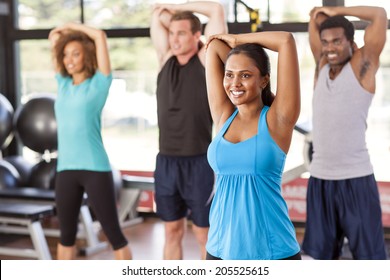 Multi-ethnic Group Stretching In A Gym Before Their Exercise Class