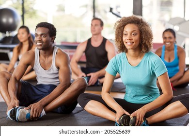 Multi-ethnic Group Stretching In A Gym Before Their Exercise Class