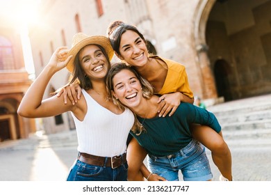 Multiethnic group of three happy young women having fun on summer vacation - Diverse female friends laughing together during their holidays - United people concept - Focus on african woman face - Powered by Shutterstock