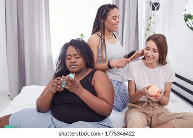 Multiethnic Group Of Three Young Lovely Females Roommates Or Friends Enjoying Home Care Procedures Together