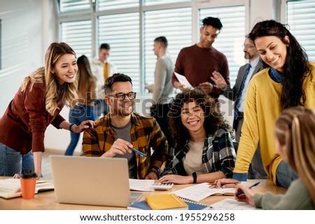 Multi-ethnic group of university students communicating and having fun while learning together in the classroom. 