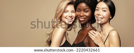Multi-Ethnic Group of women with different types of skin together against a beige background. Diverse ethnicity women - Caucasian, African and Asian.
