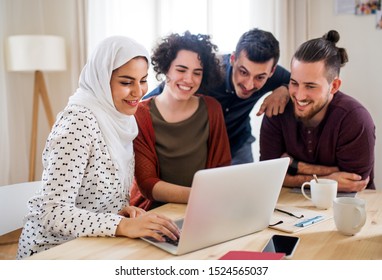 A Multi-ethnic Group Of Young Friends With Laptop Indoors, House Sharing Concept.