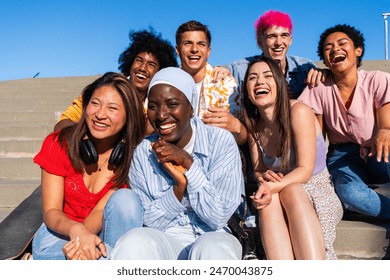 Multiethnic group of young happy friends hanging out in the city - Multiracial group of students meeting and having fun outdoors, concepts about youth, teenage, diversity and lifestyle - Powered by Shutterstock