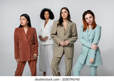 Multiethnic Group Of Young Models In Pastel Color Suits Posing On Grey