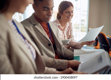 Multiethnic Group Of Young People Reading Scripts At Business Seminar In Conference Room, Exchanging Ideas And Opinions 